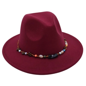 Close-up of wine red fedora hat featuring ethnic beaded band and floral metal accents