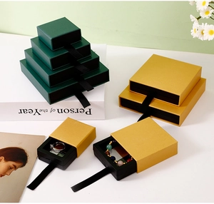 Detail of dark green and gold drawer-style jewelry boxes for rings and necklaces