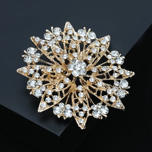 Detailed view of luxury gold rhinestone sunflower brooch on a dark pedestal stand