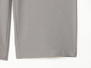 Detailed close-up of dark grey pinstripe trouser hem with high-quality woven fabric texture