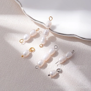 Macro view of natural freshwater pearl connectors with gold and silver metal charms