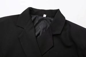 Détail du revers d'un blazer noir classique avec coutures de qualité et doublure lisse