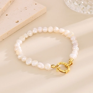 Gros plan détaillé d'un bracelet en perles d'eau douce baroques et fermoir doré