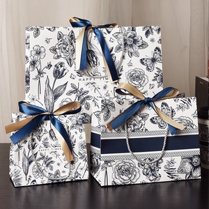Three premium floral gift bags with elegant blue flower patterns and ribbon handles