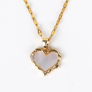 Macro view of gold shell heart pendant with white mother of pearl and zircon stones
