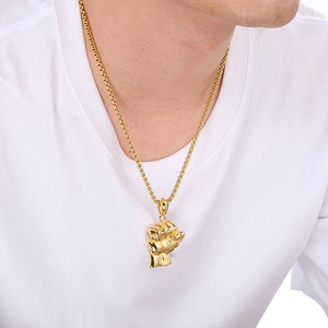 Detailed view of a gold-plated fist pendant on a stylish beaded chain for men