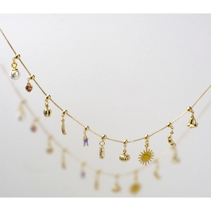 Golden DIY heart pearl pendant necklace set with sun and moon charms on grey background