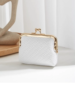 Macro detail of white woven texture and golden vintage kiss-lock on mini coin purse