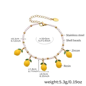 Detailed view of daisy shell beads and yellow resin lemon pendants with green zircon leaves