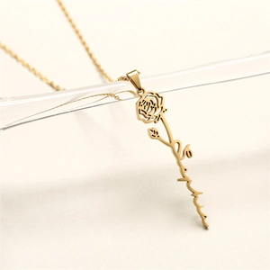 Detail of personalized gold rose necklace with custom name script on acrylic stand