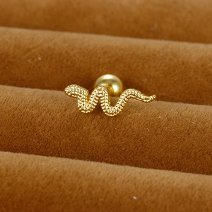 Gros plan d'un piercing serpent doré avec texture granulée et fermoir à boule vissée