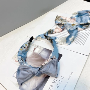 Detail of light blue floral bow headband set with matching long ribbon on magazine