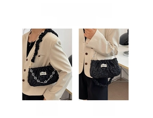 Detail showing the pleated cloud bag worn as a shoulder and handbag with silver heart chain