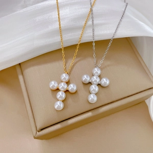 Detail of gold and silver pearl cross necklaces on elegant silk and jewelry box display