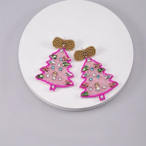 Detail of pink beaded Christmas tree earrings with colorful crystals on white stand