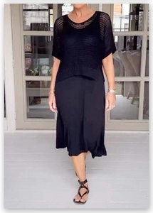 Dettaglio del top nero in maglia traforata a maniche corte con gonna midi drappeggiata