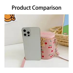 Pink girl's cherry print bucket bag shown with smartphone for size comparison