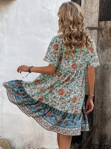 Detail of the boho floral dress back view against a rustic wooden door and white wall