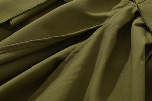 Dettaglio ravvicinato della trama del tessuto verde militare e cuciture dell'abito elegante