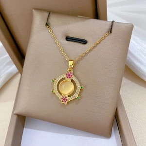 Close-up of a gold cat eye stone pendant necklace with sparkling diamonds and gemstones