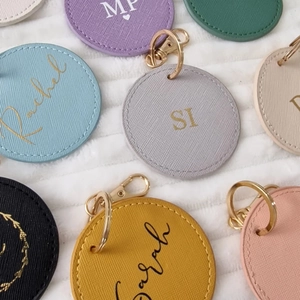 Flat lay of colorful Saffiano leather keychains with personalized gold foil embossing