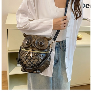 Close-up of owl box bag featuring 3D embossed feather textures and metallic finish