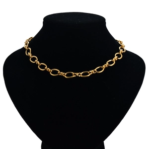 Detailed view of a golden oval link chain necklace displayed on a black velvet bust