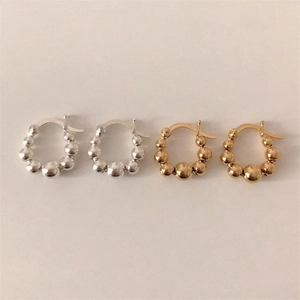 Detailed view of gold and silver beaded hoop earrings with 925 sterling silver hallmarks