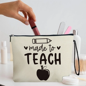 Canvas makeup bag featuring 'made to TEACH' slogan and pencil graphics with accessories