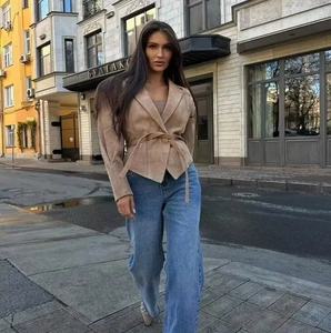 Close-up of khaki suede biker jacket with adjustable belt and street style fashion details