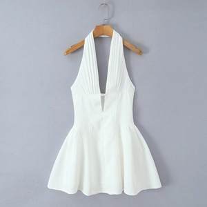 Detail of white halter dress featuring a deep V-neckline and elegant pleated texture