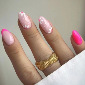 Detailed view of a wide gold mesh ring with honeycomb texture worn with floral nail art