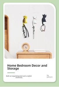 Three cute cartoon cat hooks used for hanging glasses and jewelry on a bedroom wall