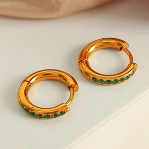 Boucles d'oreilles élégantes en titane plaqué or 18K avec zircon vert sur fond en soie
