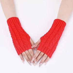 Detail of red cable knit arm warmers showing thick braided texture and fingerless design