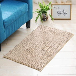 Beige chenille bath mat with soft absorbent microfibers on a classic wooden floor
