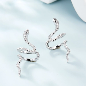 Macro view of silver snake ear cuffs featuring detailed scale textures and spiral design