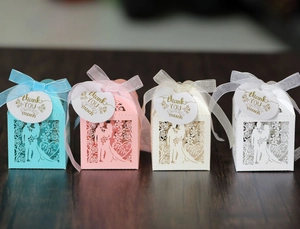 Detail of laser-cut wedding favor boxes with Mr & Mrs pattern in four assorted colors
