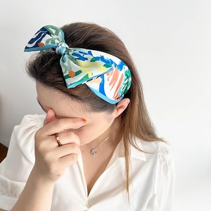 Detail of colorful abstract print headband with a stylish knot on a female model