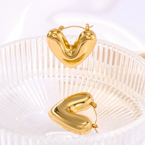 Chic 18K gold plated stainless steel hollow heart hoop earrings in a glass bowl