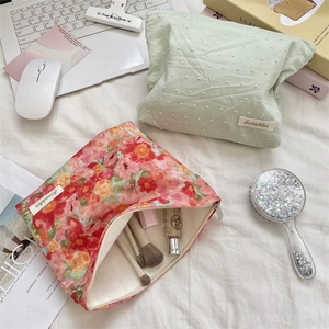 Flat lay of floral and polka dot toiletry bags showing spacious interior for makeup brushes