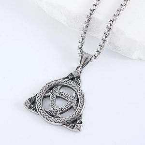 Macro d'un pendentif triangle nœud celtique argenté sur chaîne box et pierre blanche