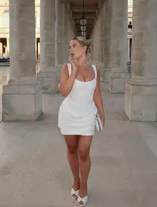 Dettaglio dell'abito corto bianco a corsetto con orlo pieghettato e tessuto lucido