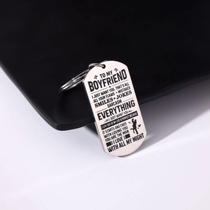 Detail of engraved stainless steel military tag keychain with romantic quote and silhouette