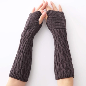 Close-up of dark coffee cable knit arm warmers with a fingerless design and thick wool texture