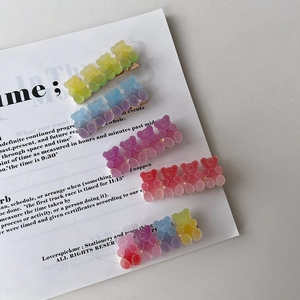 Detail of five colorful matte gummy bear hair clips with vibrant gradient jelly textures