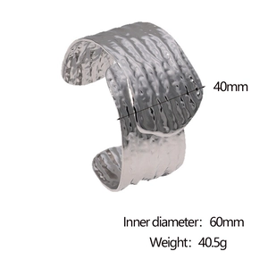 Detail of 40mm wide stainless steel C-shape cuff with textured surface and silver finish