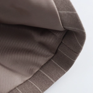 Detailed close-up of brown striped vest fabric with high-quality lining and precise stitching