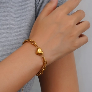 Fashionable gold link chain bracelet with heart charm on female wrist in professional shot