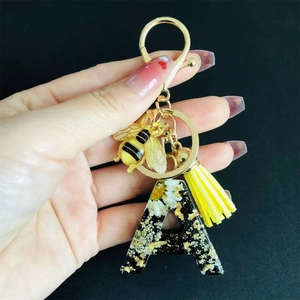 Letter A resin keychain with real dried flowers, gold foil, bee charm and yellow tassel